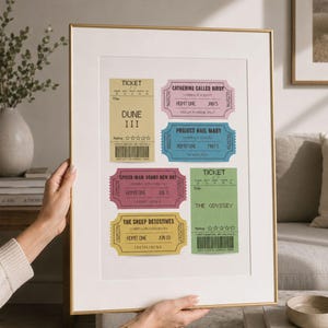 May include: A framed print featuring six colorful movie ticket stubs with titles including Dune III, Catherine Called Birdy, Project Hail Mary, Spider-Man: Brand New Day, The Sheep Detectives, and The Odyssey, displayed in a gold-toned metal frame.