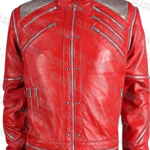 Pode incluir: Uma jaqueta de couro vermelho vibrante com gola alta e vários zíperes prateados. Os ombros apresentam um design de malha prateada. A jaqueta tem um design clássico com fecho de zíper completo e vários bolsos.