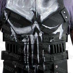 Puede incluir: Chaleco táctico negro con un diseño de calavera blanca en la parte delantera. El chaleco tiene múltiples bolsillos y correas, con el texto "CLASSIC JACKET" visible. Un accesorio de disfraz.