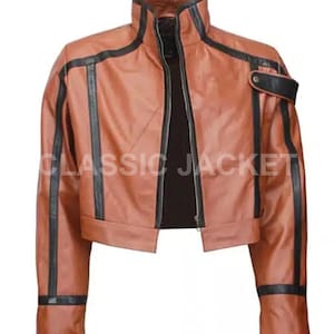 Peut inclure: Veste en cuir marron avec des détails noirs et un col montant. La veste a une fermeture éclair et le texte "CLASSIC JACKET" est visible. Des rayures noires ornent les manches et les épaules.