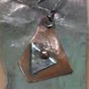 May include: A triangular copper earring with a silver geometric design and a small, round, dark brown stone in the center.