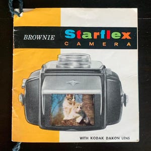 May include: A vintage "Brownie Starflex Camera" brochure. The brochure features a black and silver camera illustration with a picture of two kittens inside. The brochure has a yellow and white background with the text "Starflex Camera" in colourful letters.