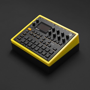 以下が含まれることがあります： 前面に「Digitakt」の文字が入った、黒と黄色の電子音楽制作デバイス。デバイスには、多数の黒いボタン、ノブ、小さな画面があります。フレームは明るい黄色で、ベースは黒です。