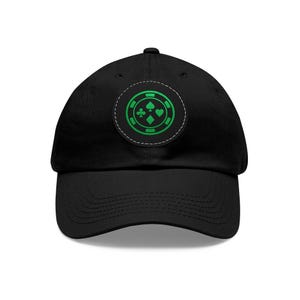 May include: Black baseball cap with a green poker chip design. The chip features green suit symbols: clubs, spades, diamonds, and hearts. The cap is made of a soft material and has a curved brim.