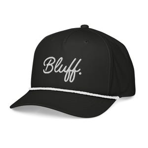 May include: Black baseball cap with a curved brim and a white rope detail. The word "Bluff" is embroidered in white cursive script across the front. The cap is a solid black color.