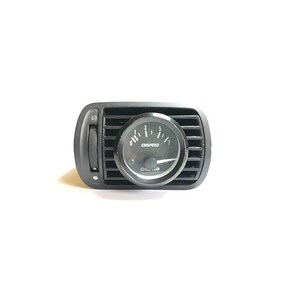 Puede incluir: Un medidor de ventilación de coche negro con una esfera redonda negra. El medidor indica "CHSPEED" y "OIL KG". El medidor está colocado en una carcasa de plástico negro con rejillas de ventilación ajustables.