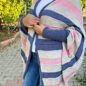 May include: A striped knit cardigan in shades of blue, pink, and beige. The open-front sweater features long sleeves and a relaxed fit. The cardigan is a cozy and stylish layering piece.