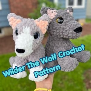 Puede incluir: Dos juguetes de lobo de peluche hechos de hilo suave gris y blanco. El lobo de la izquierda tiene la cara y el pecho blancos, mientras que el de la derecha es gris sólido. Ambos tienen orejas internas rosas y narices negras. El texto Wilder The Wolf Crochet Pattern es visible.