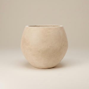 May include: A beige, egg-shaped planter with a wide opening. The planter has a textured surface and a rounded base. The neutral color and simple design make it suitable for various plants and decor styles.