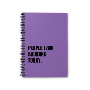Op de afbeelding: Een paars spiraalgebonden notitieboek met de tekst "PEOPLE I AM AVOIDING TODAY" in zwart. Het notitieboek heeft een zilveren spiraalbinding. De kaft is effen paars.