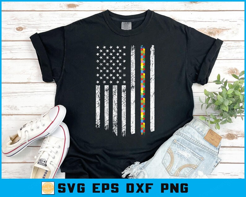 May include: Black t-shirt with a distressed American flag design, incorporating a vertical stripe of colourful puzzle pieces. The shirt has the text "SVG EPS DXF PNG" at the bottom. White trainers and denim shorts are also visible.