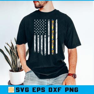 May include: Black t-shirt with a distressed American flag design. The flag's stripes include a colourful puzzle piece pattern, with white stars. The shirt is a crew neck and has short sleeves.