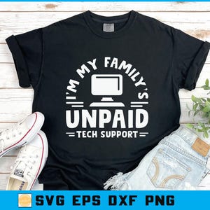 May include: Black t-shirt with the text "I'M MY FAMILY'S UNPAID TECH SUPPORT" in white. The design includes a computer monitor graphic. White sneakers and blue jeans are also in the image.