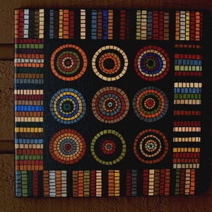 May include: Square canvas art with a black background featuring a mosaic design. The mosaic includes colorful concentric circles and rectangular patterns in shades of red, orange, blue, green, and brown. The artwork has a textured appearance.