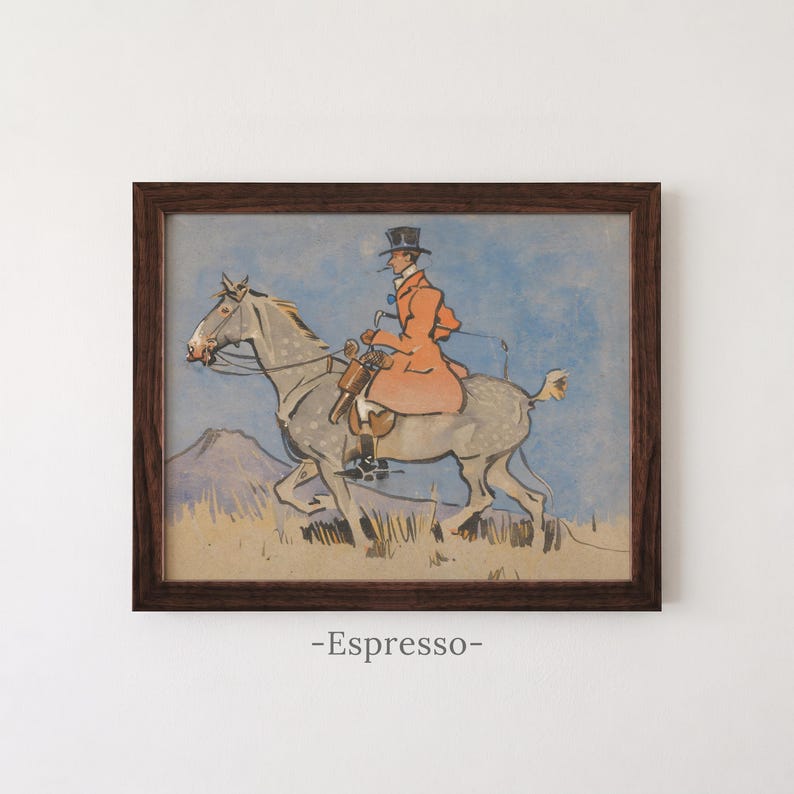 May include: A framed print featuring a stylized illustration of a rider in a top hat and orange coat mounted on a dappled gray horse. The scene includes a blue sky and a tan landscape. The word -Espresso- is printed below the dark wood frame.
