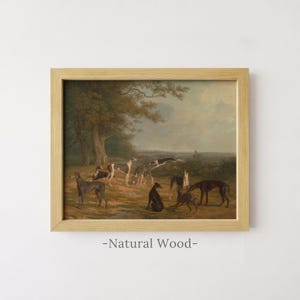 May include: A framed landscape painting featuring a group of greyhounds in a field with trees under a cloudy sky. The artwork is enclosed in a light-coloured natural wood frame. The text -Natural Wood- is printed below the framed artwork.