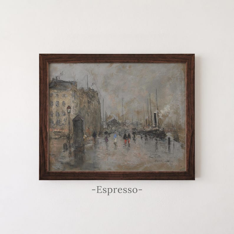 May include: A framed oil painting depicting a rainy cityscape with buildings, a street lamp, and figures walking along a wet harbor. The artwork features muted gray and brown tones, with the text -Espresso- printed below the frame.