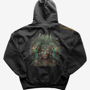 Puede incluir: Sudadera con capucha gris oscuro con un gráfico detallado de una cara con un tocado, rodeada de diseños intrincados y la palabra "GOJIRA FORTITUDE". La sudadera con capucha tiene una capucha con cordón y un bolsillo de canguro.