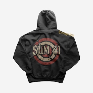 May include: Black hooded sweatshirt featuring the band name "SUM 41" in a distressed, vintage-style design. The graphic includes a red and white target with arrows. The sweatshirt has a drawstring hood and a kangaroo pocket.