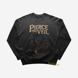 May include: Dark gray sweatshirt featuring a stylized cobra with a microphone, wearing a red bandana and a star. The text "Pierce the Veil" is arched above the snake in a vintage font. The sweatshirt is a crew neck.