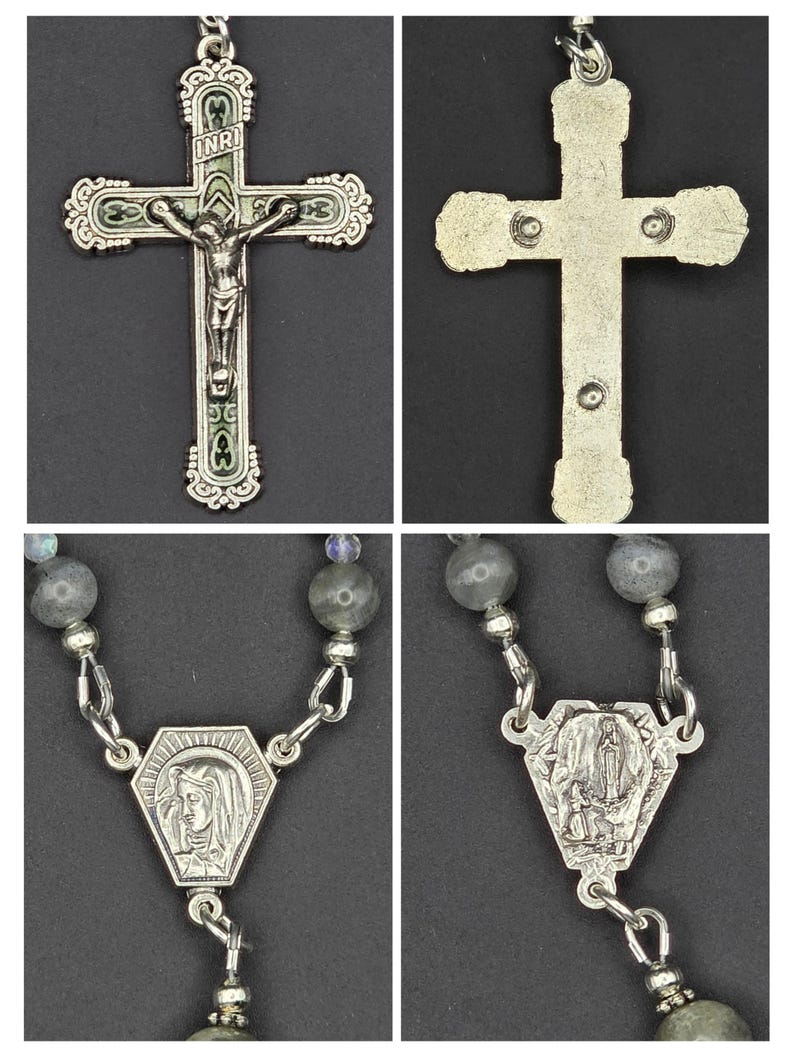 May include: A silver rosary with a detailed crucifix depicting Jesus. The rosary features grey gemstone beads and a pendant with a religious image. The cross has green enamel detailing.