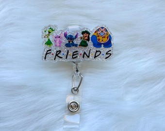 Puede incluir: Un portatarjetas brillante con personajes de dibujos animados y la palabra "FRIENDS". Los personajes incluyen un extraterrestre verde, un extraterrestre rosa, un extraterrestre azul, una niña con flores y un extraterrestre amarillo. El carrete tiene una correa de plástico transparente y un clip plateado.