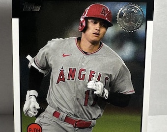 May include: A baseball card featuring Shohei Ohtani in an Angels uniform. The card has a black border with the word "ANGELS" in red. The player is wearing a gray jersey with the team name and number 17. The card also includes the Topps logo and a "35" anniversary emblem.