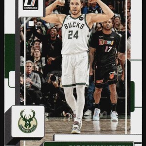 May include: A basketball trading card featuring Pat Connaughton of the Milwaukee Bucks. The card shows Connaughton flexing his arms, wearing a white jersey with the number 24. The card has the Donruss logo and the Bucks logo.