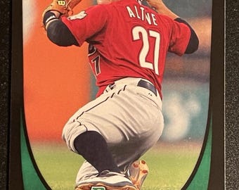 Peut inclure: Carte de baseball de Jose Altuve des Astros de Houston en action de lancer. Il porte un maillot rouge avec le numéro 27 et une casquette noire. La carte a une bordure verte et noire avec le logo Bowman.