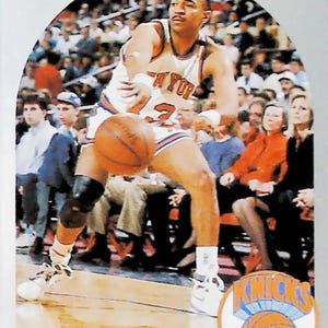 May include: A basketball card featuring Mark Jackson of the New York Knicks. The card shows Jackson dribbling a basketball, wearing a Knicks jersey with the number 23. The card has the NBA Hoops logo and the Knicks logo.