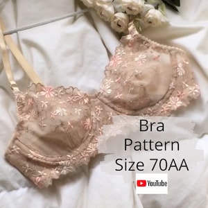 May include: A beige bra with floral embroidery and scalloped edges. The bra has adjustable straps and is displayed on a white surface. The text on the image reads "Bra Pattern Size 70AA".