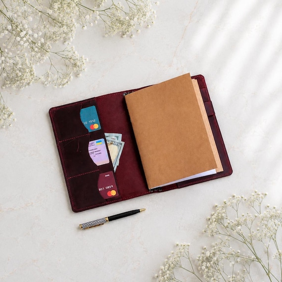 Real leather, monogrammed, with a built-in pen loop — the kind of handmade notebook cover a writer actually keeps for years.