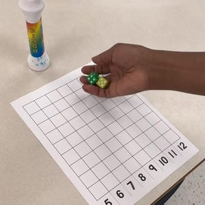 以下が含まれることがあります： 虹色のビンゴマーカー、2つのサイコロ、5から12までの数字が書かれたグリッドシートを備えたビンゴゲームセット。サイコロは緑と黄色です。ビンゴマーカーには「BINGO」の文字が印刷されています。