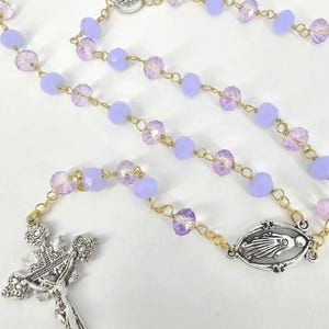 Handmade Catholic rosary with light purple and magenta-tinted prayer beads