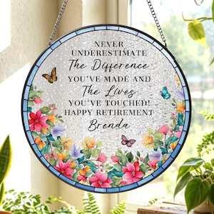May include: Round, stained-glass window art with a floral border and butterflies. The text reads, "NEVER UNDERESTIMATE The Difference YOU'VE MADE AND The Lives YOU'VE TOUCHED! HAPPY RETIREMENT Brenda."