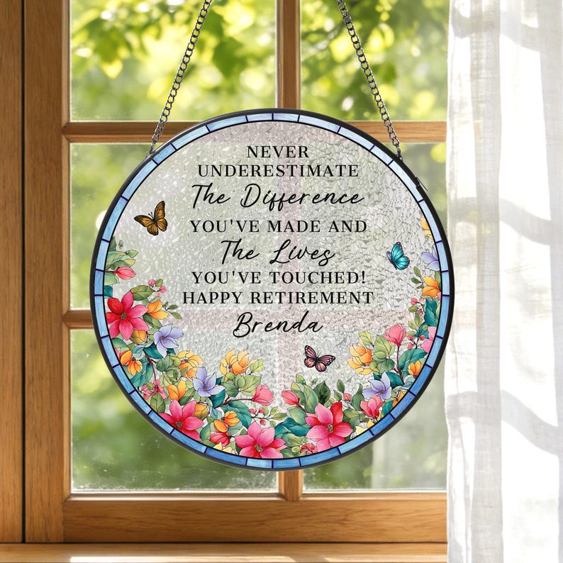 May include: Round, stained glass window art with a floral border and butterflies. The text reads "NEVER UNDERESTIMATE The Difference YOU'VE MADE AND The Lives YOU'VE TOUCHED! HAPPY RETIREMENT Brenda."