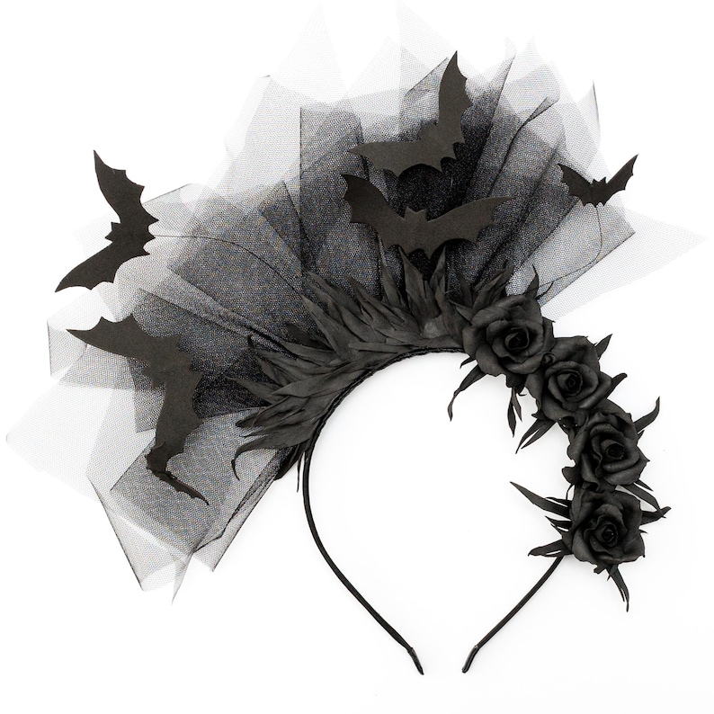 May include: A black Halloween headband featuring bat silhouettes, black roses, and a tulle veil. The headband has a curved design with a black base and is suitable for costume parties or themed events.
