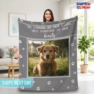 Könnte beinhalten: Graue Decke mit einem Foto eines braunen Hundes, umrahmt von Weiß und mit Pfotenabdrücken verziert. Der Text "NO LONGER BY OUR SIDES. BUT FOREVER IN OUR hearts" ist aufgedruckt.