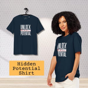 Puede incluir: Camiseta azul marino con el texto "UNLOCK Hidden POTENTIAL" en blanco y rojo. La camiseta se muestra en una percha y la lleva una persona. La imagen también incluye la etiqueta "Hidden Potential Shirt".