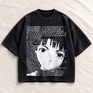 Peut inclure: Un t-shirt noir à manches courtes avec une impression graphique blanche représentant un visage de style anime superposé à des lignes de code informatique et de texte technique. Le t-shirt a un col rond et un aspect délavé sur tout le tissu.