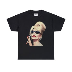 May include: Black t-shirt with a graphic of a woman with blonde hair wearing sunglasses and holding a cigarette. The woman is looking to the right and has red lipstick on.