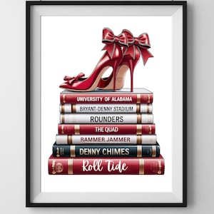 May include: A framed print featuring a pair of red high-heeled shoes with bow accents atop a stack of books. The books have titles such as "University of Alabama" and "Roll Tide". The artwork is set against a white background.