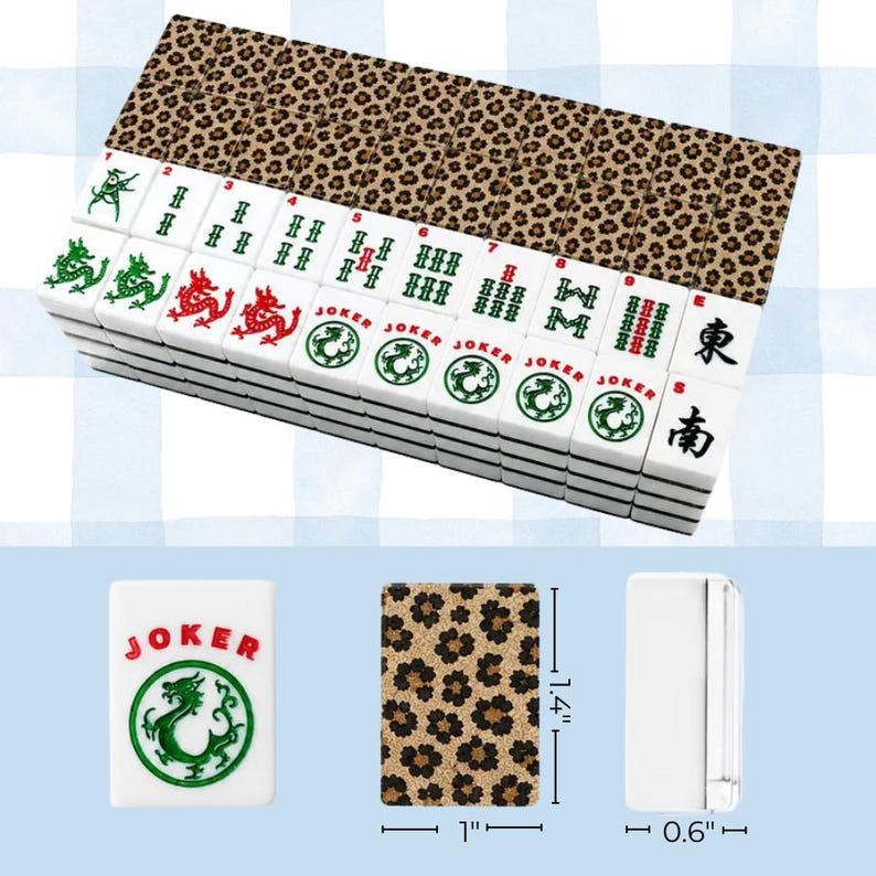 May include: A set of white mahjong tiles with leopard print backs. The tiles feature green and red dragon symbols, numbers 1 through 9, Joker text with dragon icons, and East and South characters. Individual tiles measure 1.4 inches by 1 inch by 0.6 inches.