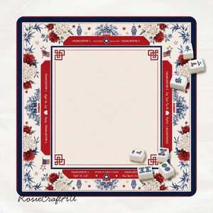 Puede incluir: Un tapete de Mahjong cuadrado con un centro color crema, un borde rojo y azul con patrones florales y texto que incluye Charleston 1 y Charleston 2. Varias fichas de Mahjong blancas con s&iacute;mbolos negros est&aacute;n dispersas en los bordes.