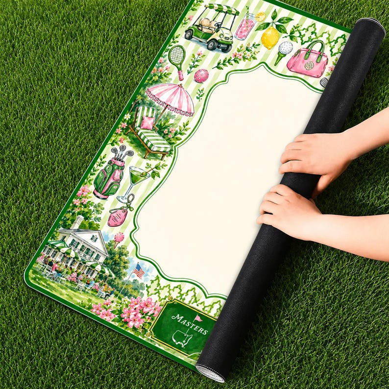May include: A rectangular mat featuring a white center panel surrounded by a green and white striped border decorated with illustrations of a golf cart, lemon, pink handbag, golf bag, lounge chair, and a clubhouse with the text MASTERS.