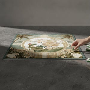 May include: A rectangular mahjong mat featuring a central circular illustration of light pink lotus flowers and green leaves. The background displays a tropical landscape with palm trees and a coastal scene in muted green and beige tones.