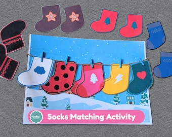 Puede incluir: Un juego de emparejar calcetines con un fondo de paisaje invernal impreso, un tendedero con cinco calcetines de papel coloridos con iconos de nube, puntos, árbol, rayo y corazón, además de varios calcetines de papel sueltos de colores.