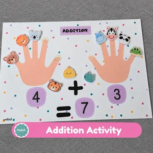 May include: An educational addition activity sheet featuring two peach-colored hand illustrations with small animal character cutouts on the fingers. The page includes the text ADDITION, the numbers 4, 3, and 7, plus and equals signs.