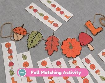 May include: A fall-themed matching activity set featuring paper strips with illustrations of acorns, leaves, pumpkins, mushrooms, and boots, alongside a string garland displaying the same autumn-inspired shapes in orange, red, and green colors.