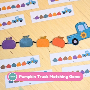 Könnte beinhalten: Ein Pumpkin Truck Matching Game bestehend aus mehreren rechteckigen Karten mit Abbildungen blauer Lastwagen, die Reihen bunter Kürbisse ziehen. Ein großer blauer Lastwagen-Ausschnitt mit Sonnenblumenmotiv ist mit einer Kette aus fünf Kürbissen verbunden.
